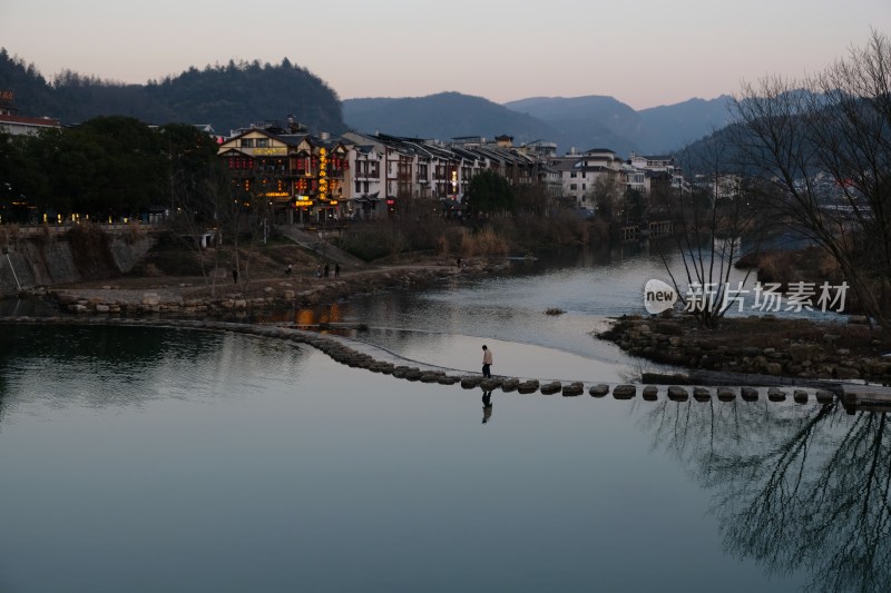 人在河边石墩上行走风景