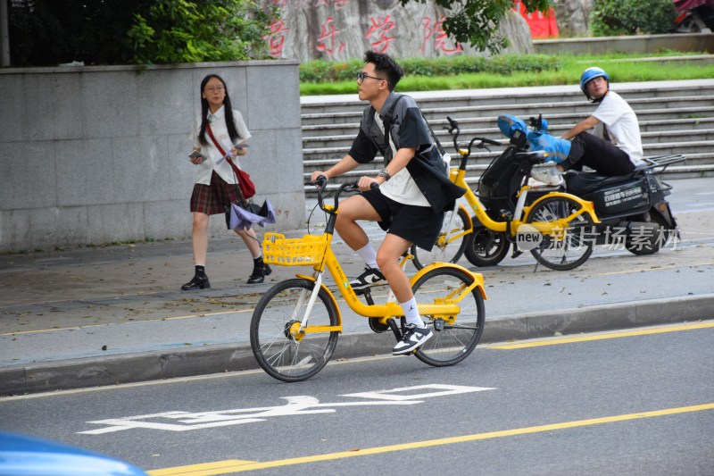 男子骑行黄色共享单车