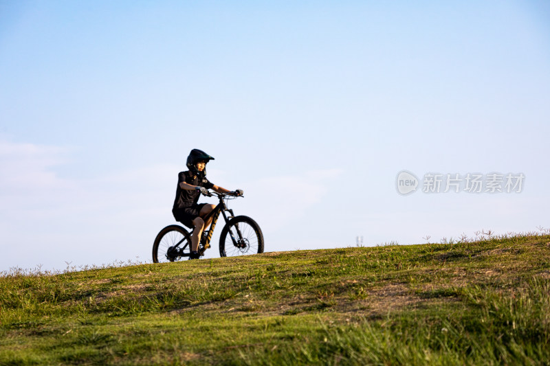 山东青岛海之恋公园海滨草坡上骑单车的少年