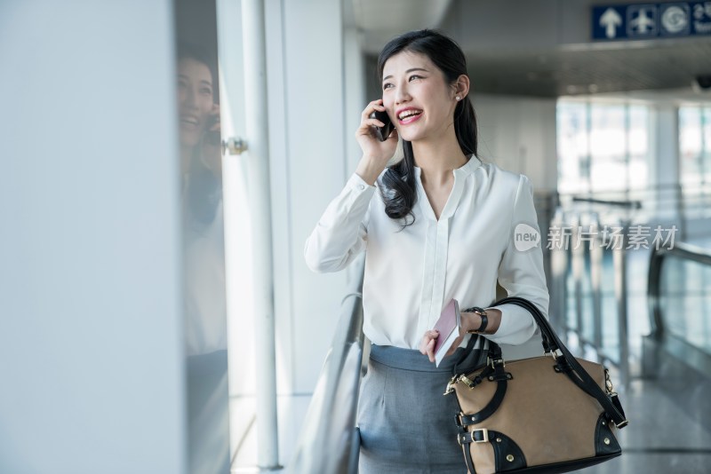 年轻商务女士在机场打电话