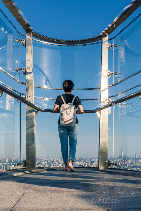 站在北京奥林匹克塔上鸟瞰城市的女性背影