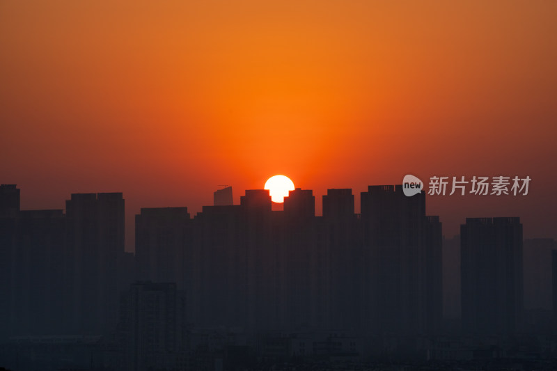 清晨城市高层住宅与日出太阳