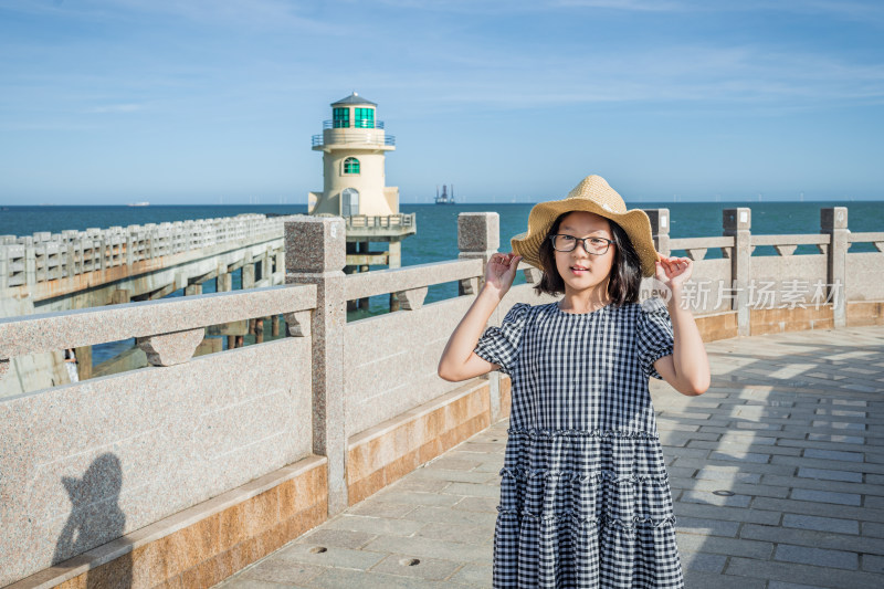 海边女孩扶草帽留影