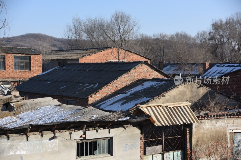 破旧砖房建筑，屋顶积雪的乡村景象