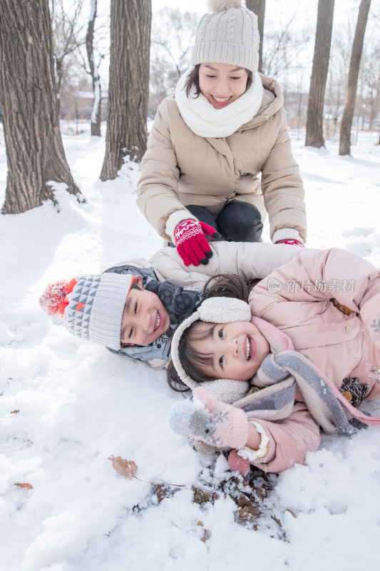 年轻妈妈和孩子们在雪地里玩耍