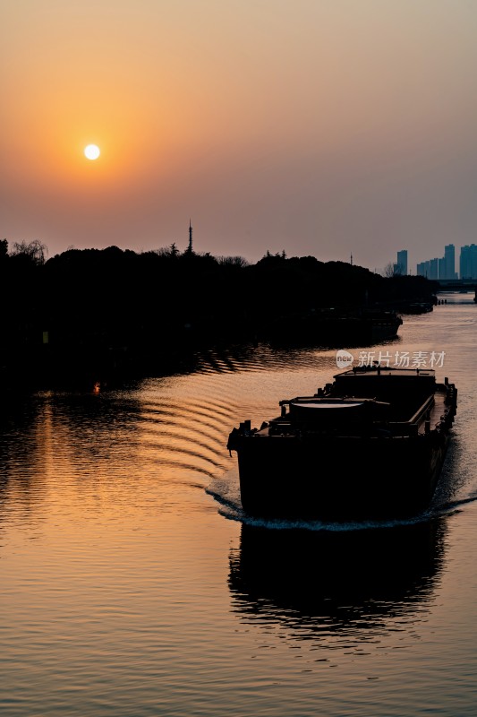 夕阳下河面行驶的货船