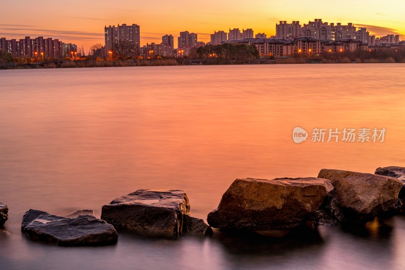 湖边日落景象，芦苇岩石相伴