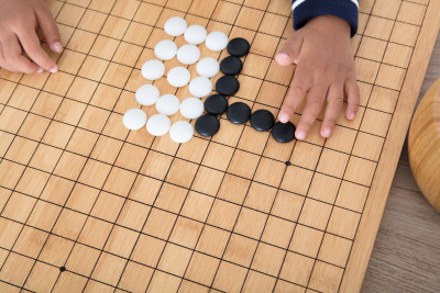 小孩子在棋盘上学习下围棋