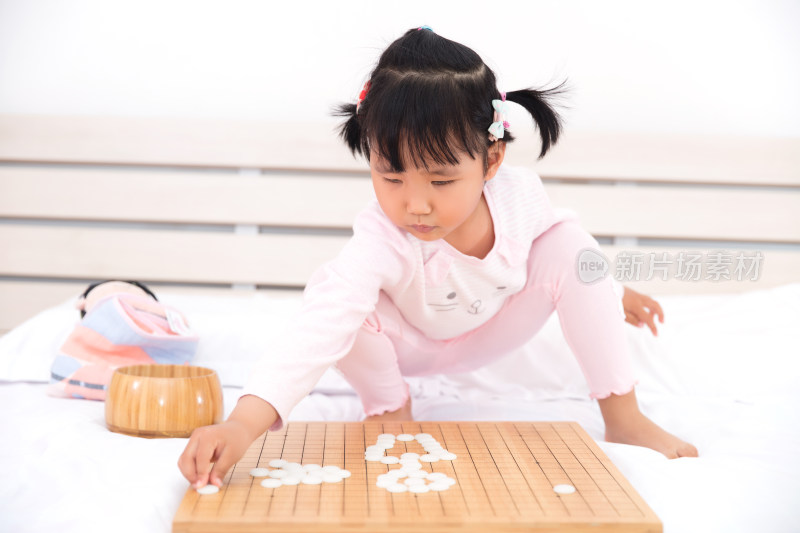 中国小姑娘兴致勃勃的摆弄围棋子