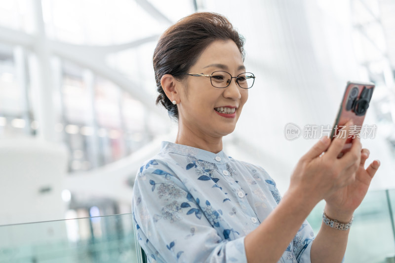 老年女人在机场使用手机