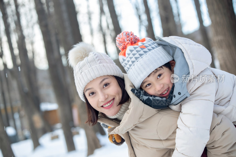 年轻妈妈带着孩子在雪地玩耍