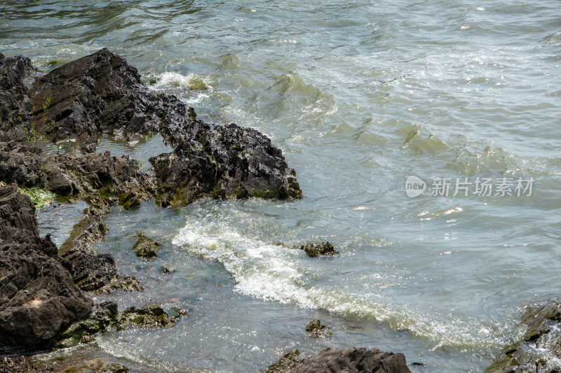 海岸边海浪拍打岩石的瞬间