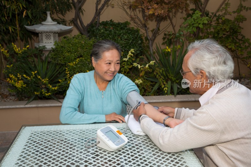 老年夫妻在院子里量血压