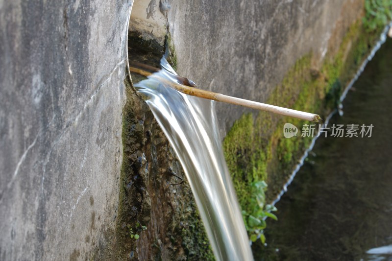 水泥墙上小孔流出一股清流