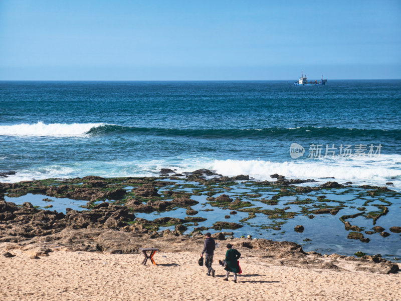 海边沙滩两人漫步场景