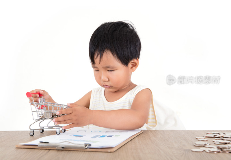 黄皮肤小女孩认真的摆弄上桌子上的购物车