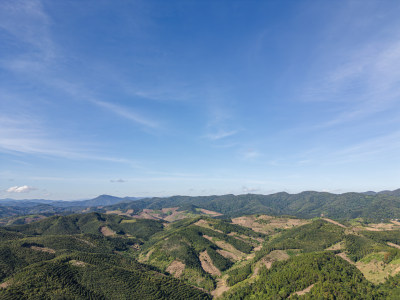 航拍蓝天白云下广阔无垠绿意盎然的山地景观