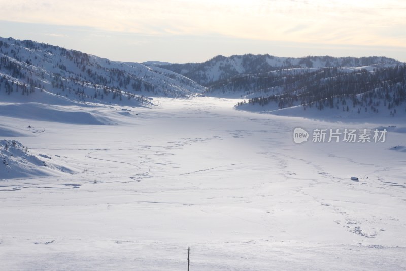 冬日雪山下的广阔雪地景观