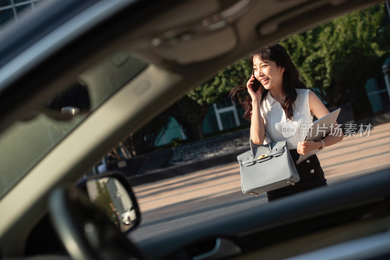 打电话的青年女人走向汽车