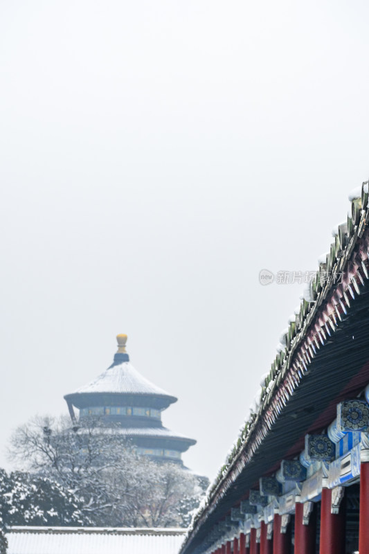 雪后古建筑屋檐与远处楼阁景观