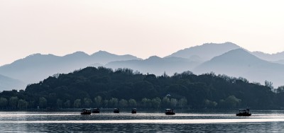 西湖山水湖面上的船只与远山风景