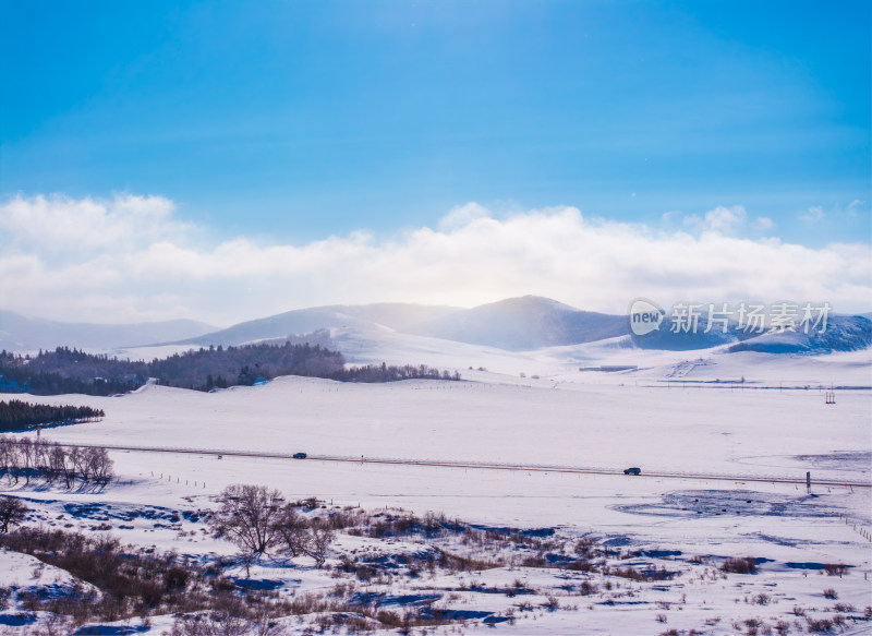 冬日雪山下的广阔雪地与公路