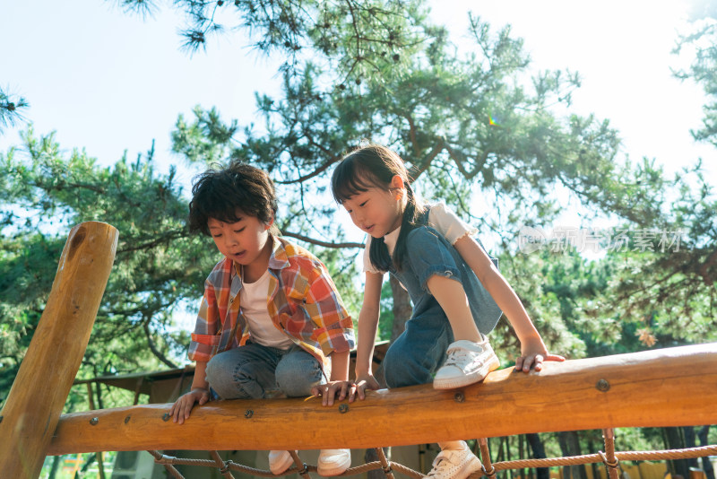 两个小孩子开心玩攀爬架