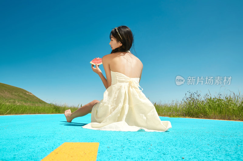夏日户外湖边彩色公路上玩耍吃西瓜的少女