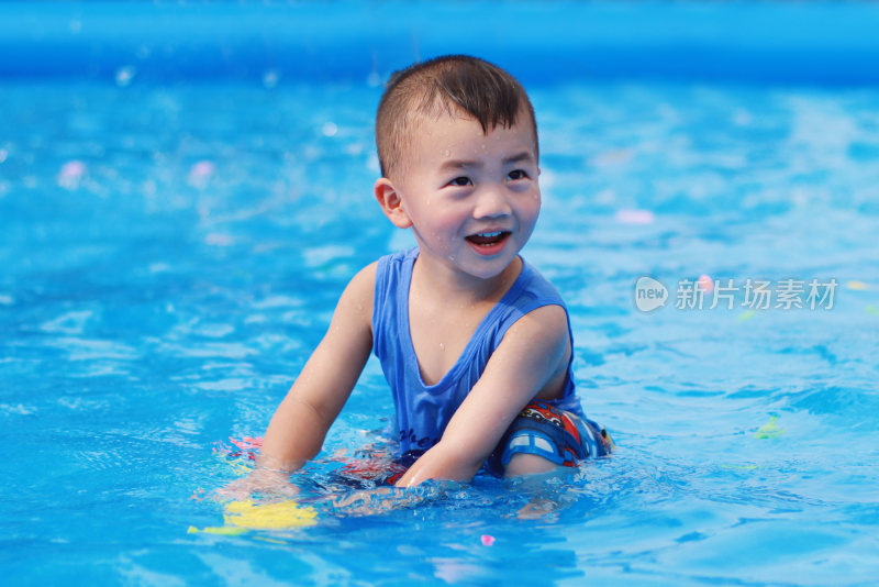 在游泳池里玩耍的小男孩