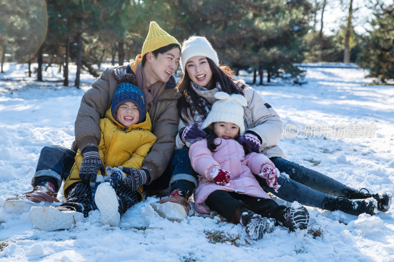 快乐的一家人坐在雪地上