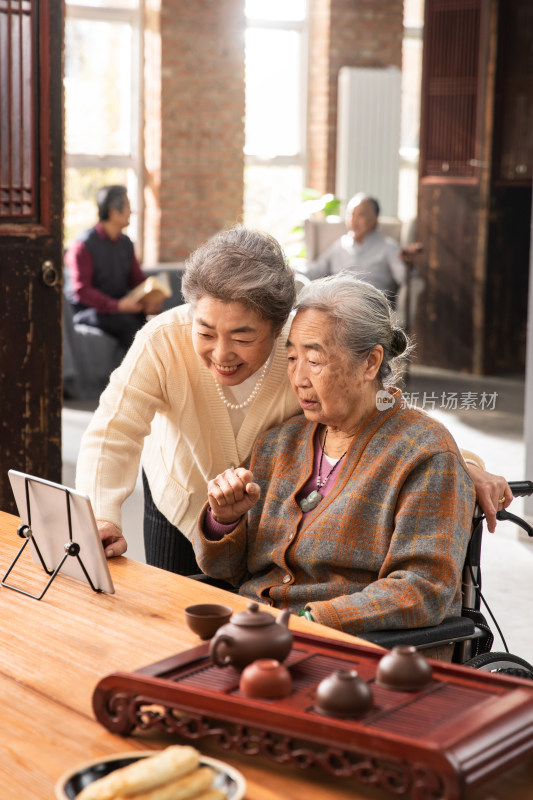 老姐妹俩用平板电脑看视频