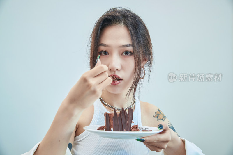 在烘焙店吃蛋糕喝饮料的可爱亚洲少女