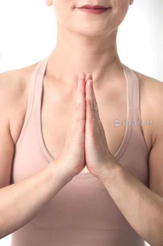 双手合十练瑜伽的中年女性部分特写