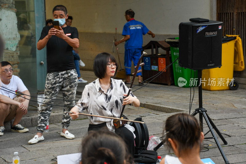 街头女子演奏二胡