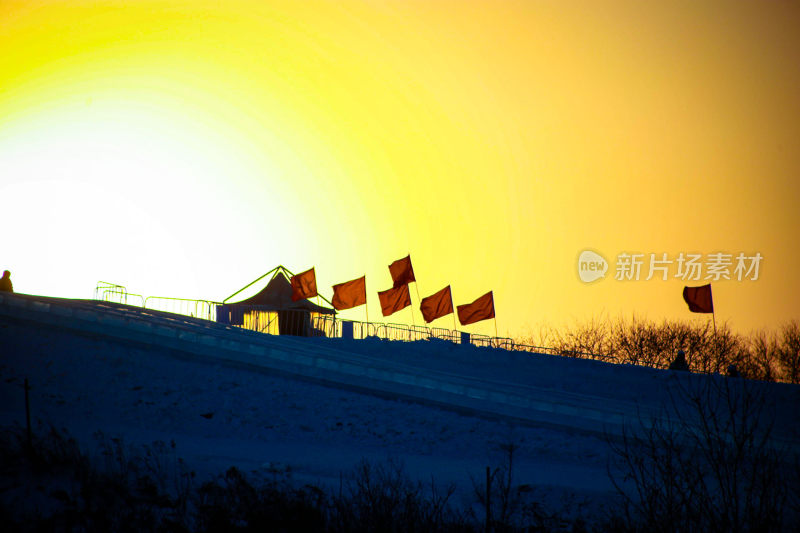 雪地上插着红旗的夕阳景象