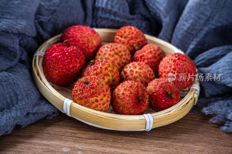 桌面上篮子里装着刚采摘下来的新鲜桂味荔枝