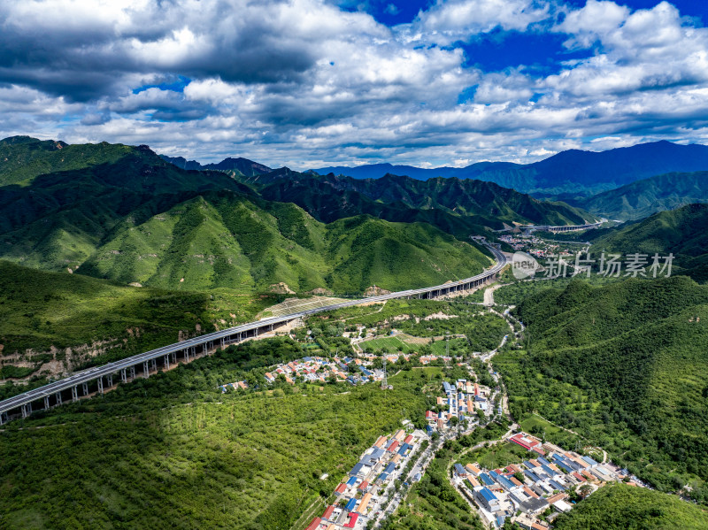 航拍京蔚高速公路蜿蜒穿过绿意盎然的山谷