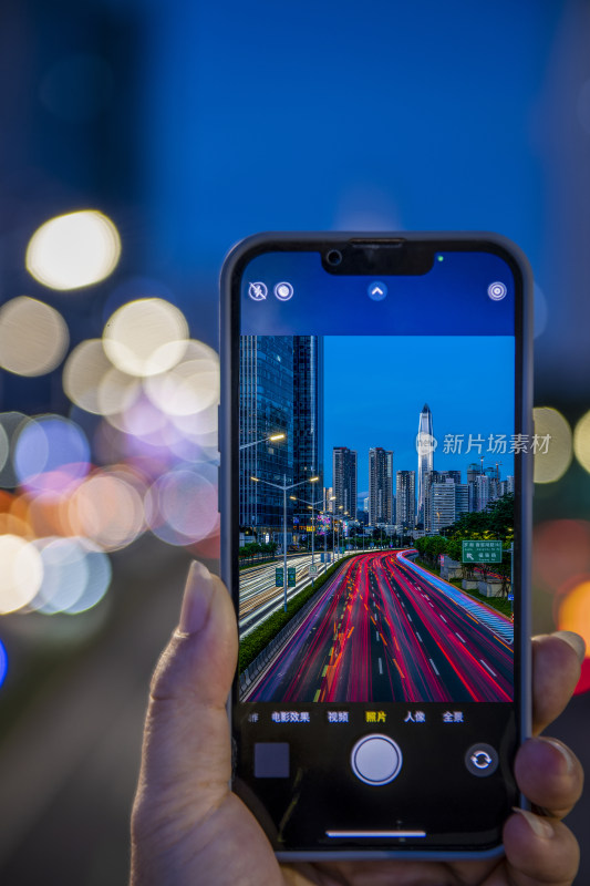 手持手机拍摄城市街道夜景