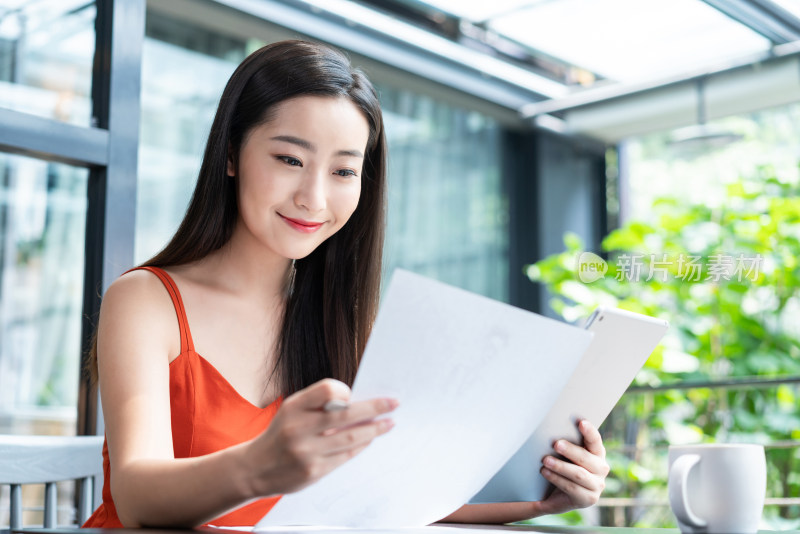 年轻女子看咖啡店使用平板电脑