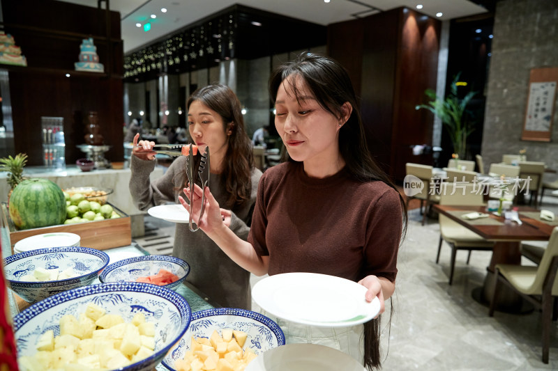 在酒店自助餐厅大吃特吃的亚洲可爱闺蜜少女