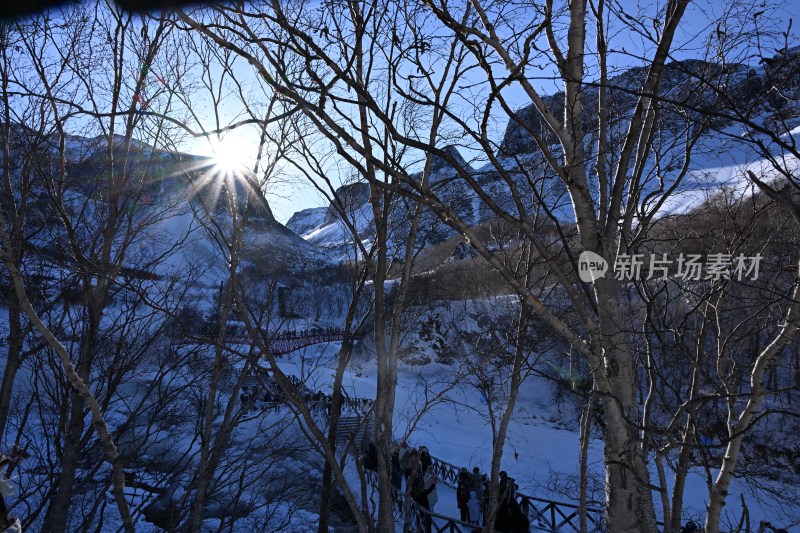 雪后山林阳光照耀下的游客景象