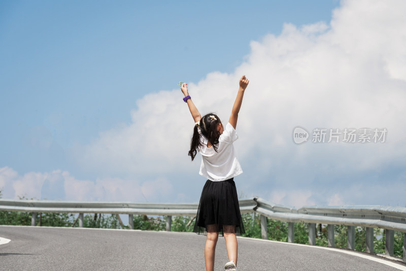 晴朗的夏天午后走在盘山公路上的东方女孩