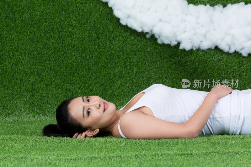 草地创意年轻女性躺在草地上
