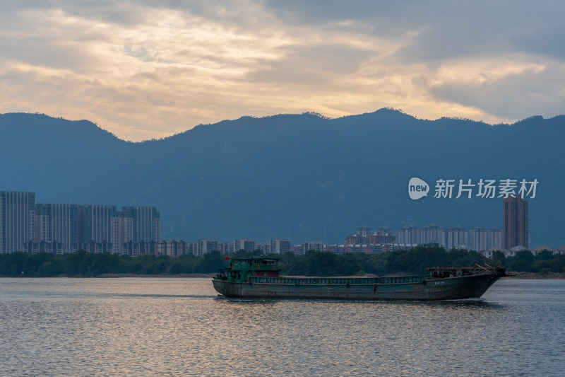 江面上行驶货船的城市山水风景