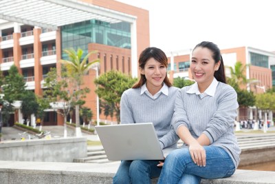 年轻大学生在校园里使用笔记本电脑