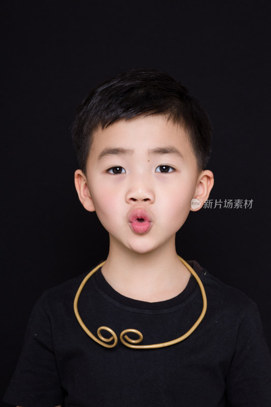 黑色背景下可爱的中国小男孩肖像