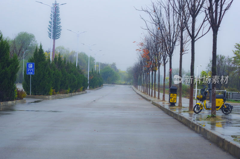 雾天湿滑空旷道路旁有停车牌和电动车