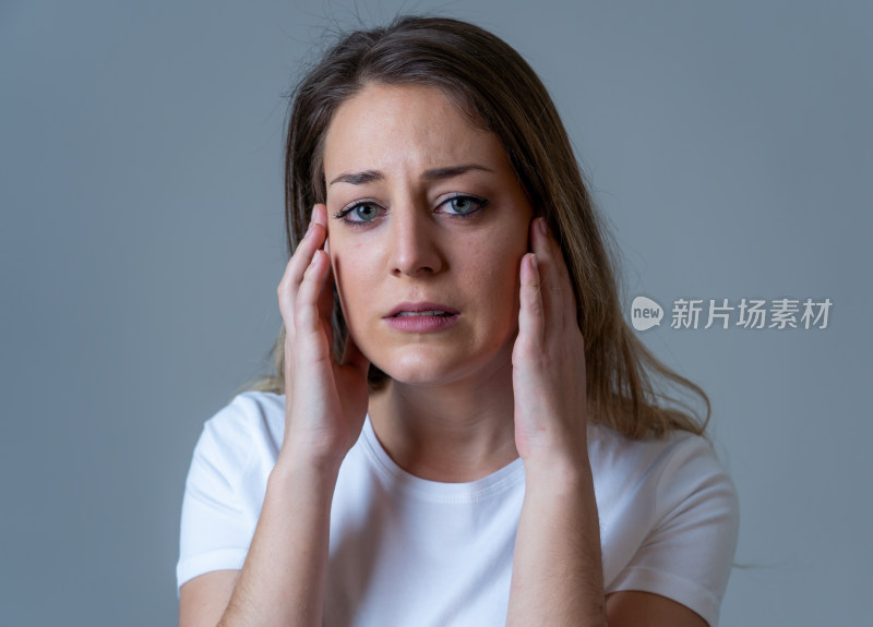 女性双手扶脸神情苦恼