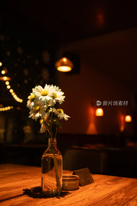 餐厅木桌花瓶中的雏菊花束