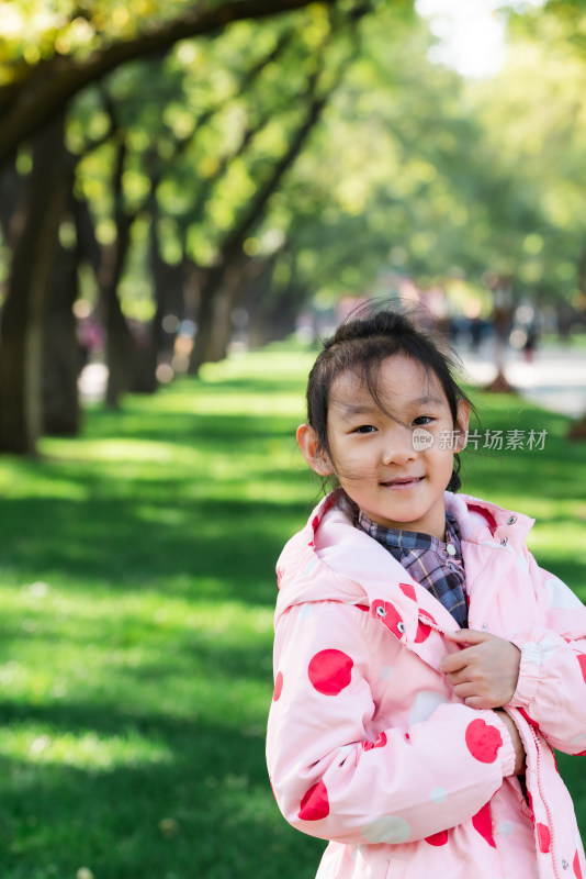 秋天站在公园草坪上的中国女孩